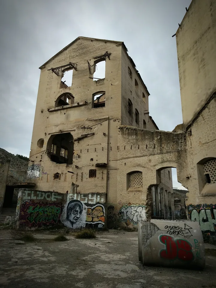 Edificio de piedra con una torre y grafitis en primer plano