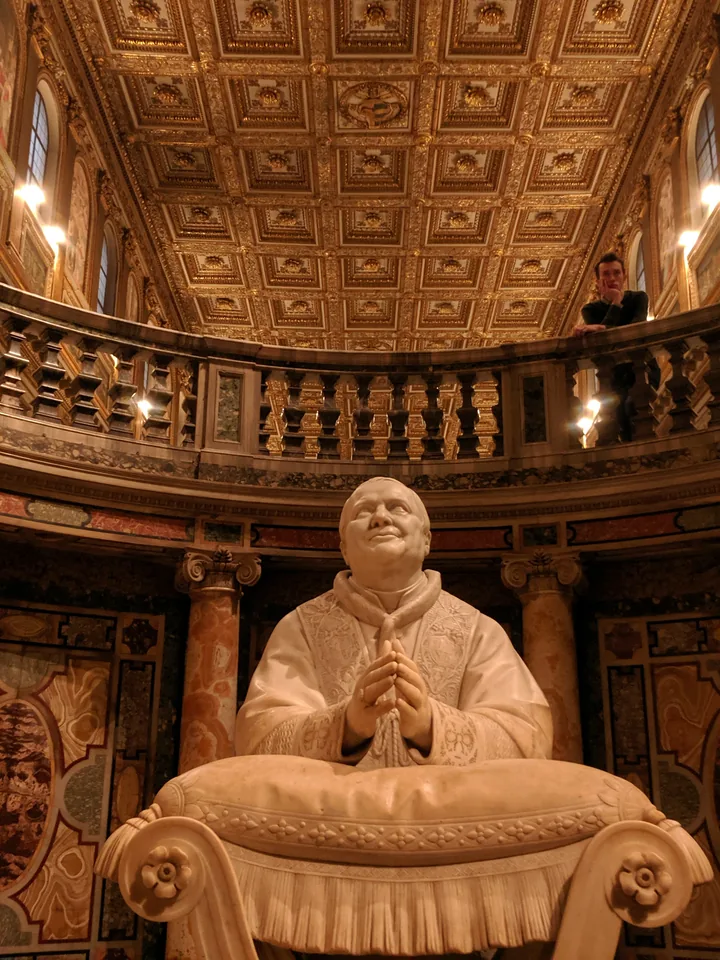 Escultura sentada en el interior de una biblioteca histórica