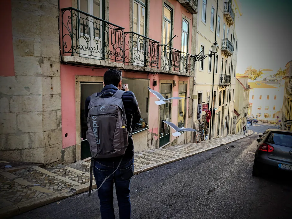 Persona con mochila bajando una calle estrecha de fachadas de colores