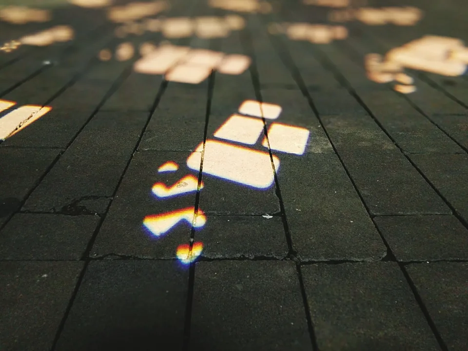 Luz y sombras coloreadas sobre las baldosas de un suelo