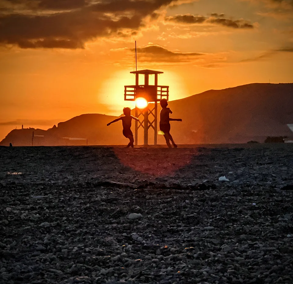 Torre de vigilancia en una playa a contraluz durante un atardecer naranja